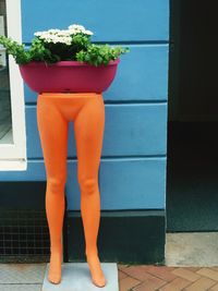 Low section of woman standing on potted plant