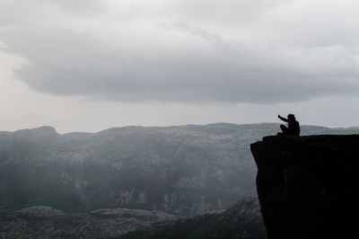 View of a horse on rock against sky