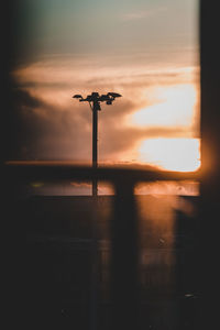 Silhouette street light against sky during sunset