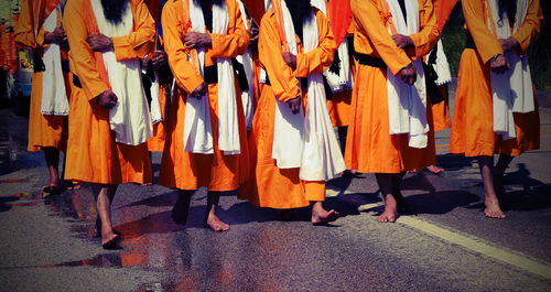 Low section of men walking on street during traditional festival