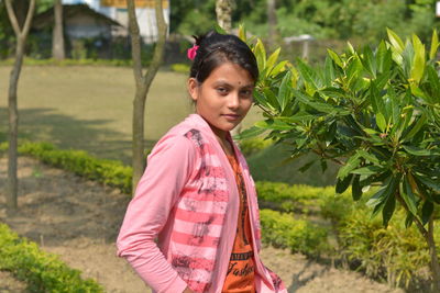 Portrait of young woman against plants