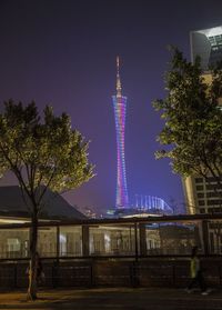 Illuminated skyscraper in city against clear sky at night