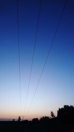 Low angle view of silhouette trees against clear sky