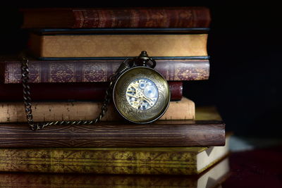 Close-up of pocket watch with books