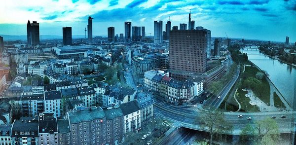 Skyscrapers in city against cloudy sky