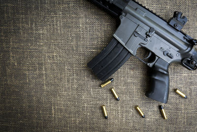 Directly above shot of gun and bullets on table