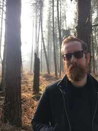 Portrait of bearded man wearing sunglasses in forest