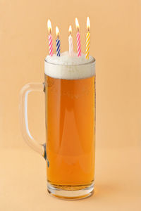 Conceptual closeup pint of beer birthday with candles