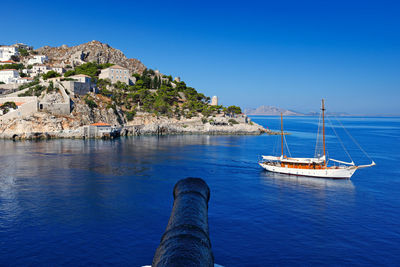 Sailboat sailing on sea against clear blue sky