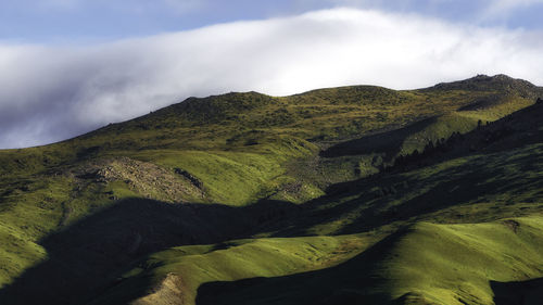 Scenic view of mountains against cloudy sky