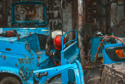 A local mechanic working on a bajaj in his garage
