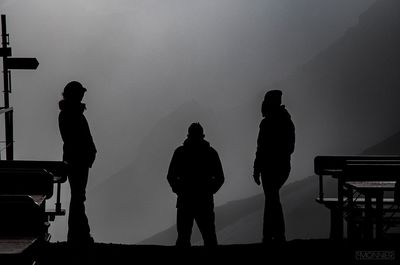 Silhouette friends standing at observation point against sky