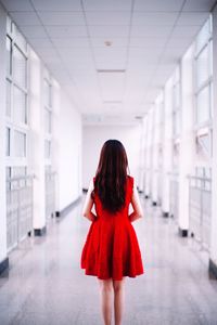Rear view of young woman standing in corridor