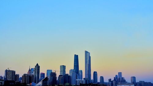 Modern buildings against clear sky during sunset