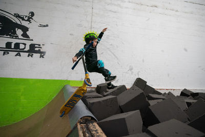 Full length of boy jumping on wall