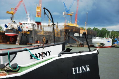 Boats moored at harbor against sky