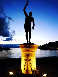 Silhouette man by sea against sky during sunset