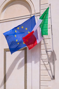 Low angle view of flag against built structure
