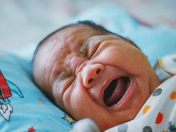 Close-up of cute baby boy sleeping on bed