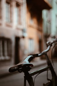 Close-up of bicycle parked on street against building