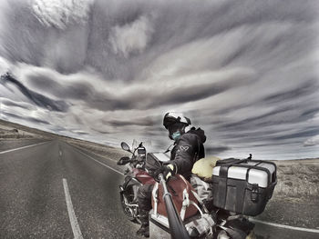 People on road against cloudy sky