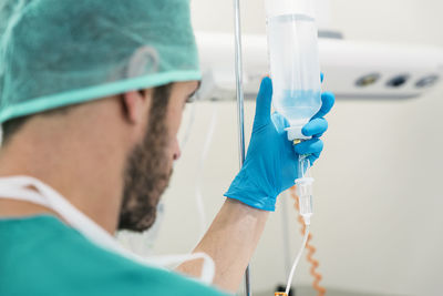 Close-up of doctor holding iv drip in hospital