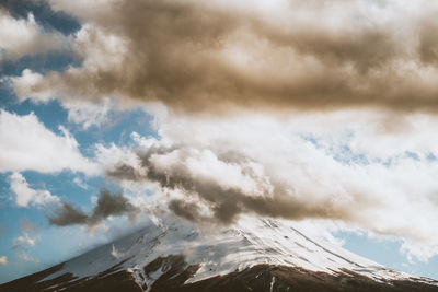 Low angle view of snowcapped mountain against sky