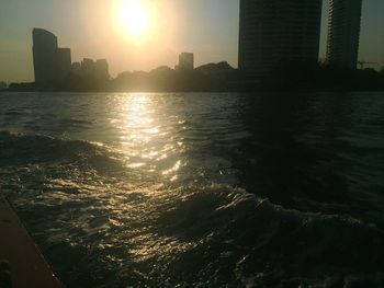 View of city at waterfront during sunset