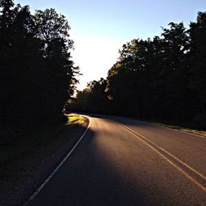 Empty road along trees