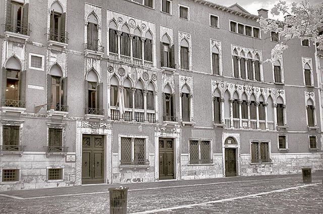 building exterior, architecture, built structure, window, building, city, residential building, street, facade, residential structure, outdoors, day, sunlight, in a row, no people, city life, incidental people, sidewalk, cobblestone, shadow