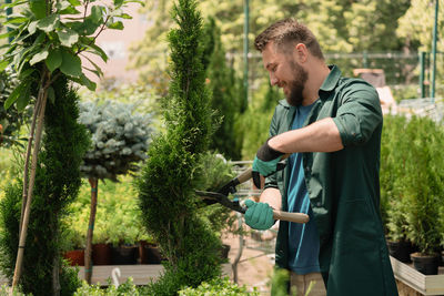 Side view of young man watering plants