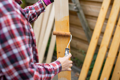 To cover wooden boards with colored varnish with a roller person