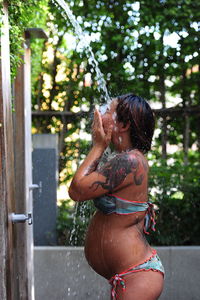 Young woman at shower outdoors