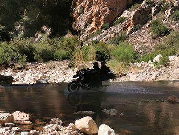 People on rocks by river