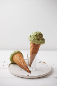 Close-up of ice cream on table against white background