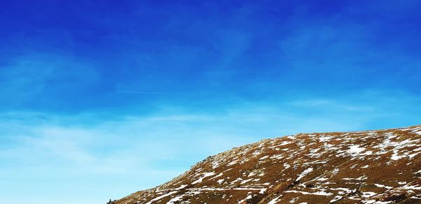 Low angle view of mountain against blue sky