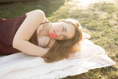 High angle view of young woman sitting on field