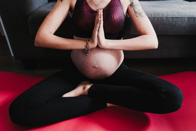 Low section of pregnant woman sitting at home