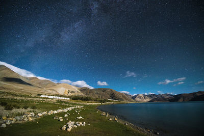 Scenic view of lake against sky at night