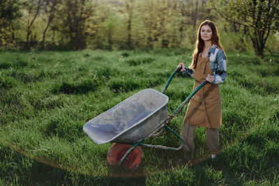 Portrait of young woman standing on grassy field