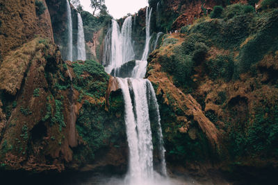 Low angle view of waterfall falling from mountain