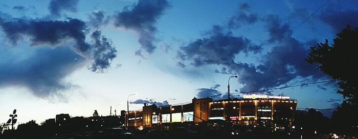 Low angle view of illuminated street light against cloudy sky