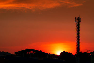 Silhouette of building against orange sky