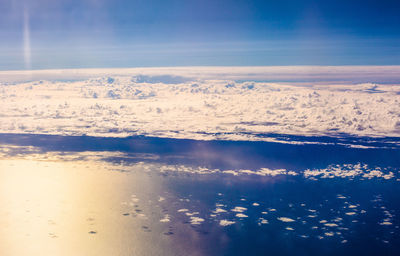 Clouds hovering above the vast reflective ocean waters below - queenstown, new zealand