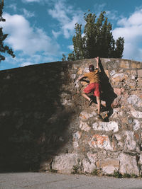 A man climbing a stone wall