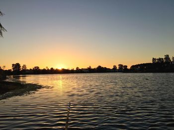 Scenic view of lake against clear sky during sunset