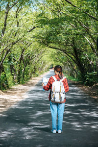 Full length of man standing on road in forest