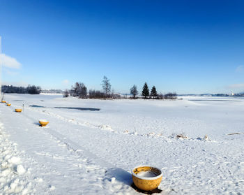 Scenic view of snow covered landscape against blue sky