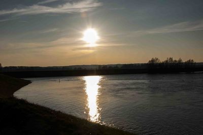 Scenic view of river against sky at sunset