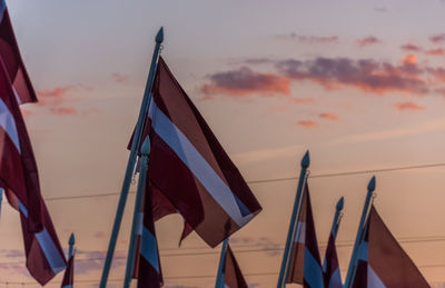 Low angle view of flags against sky during sunset